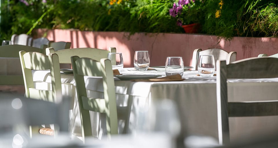 Courtyard tables with green chairs in daylight
