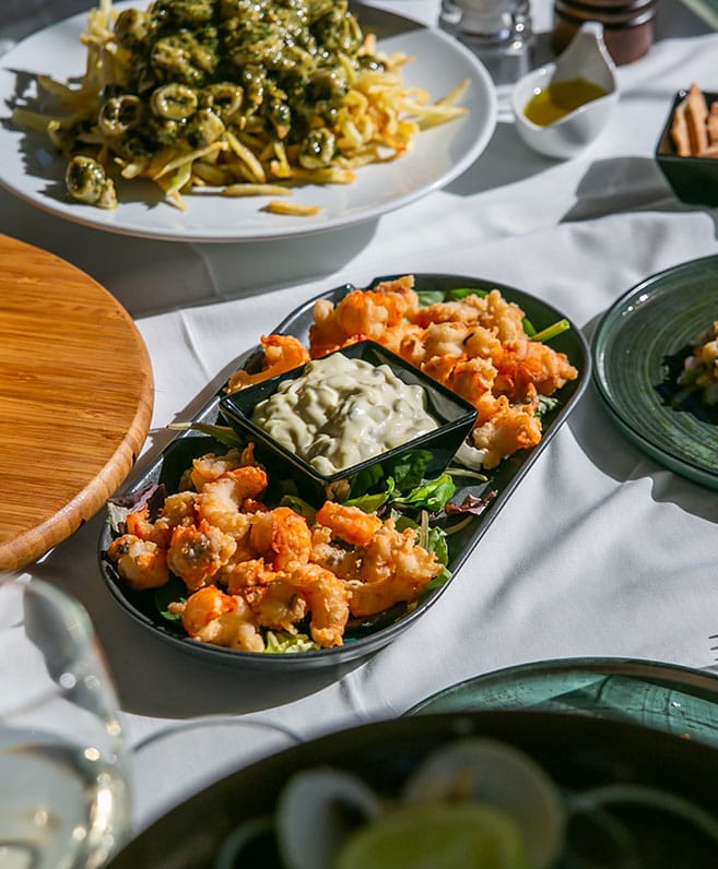 Fried mussels with greens on a set table